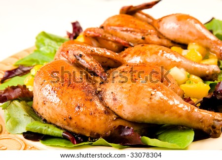 Cornish hen halves served on a bed of lettuce with mango salsa