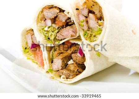 Sliced beef in a wrap with sprouts, mushrooms, and tomato