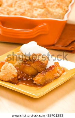 Peach cobbler served with whipped cream