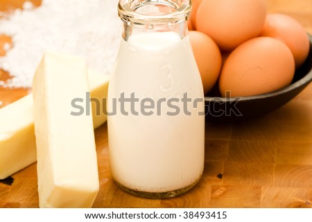 Milk, Eggs, Butter, and flour on cutting board ready to be used in cooking and baking