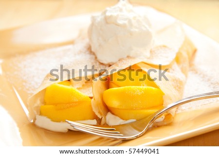 Peach crepes with a large dollop of whipped cream
