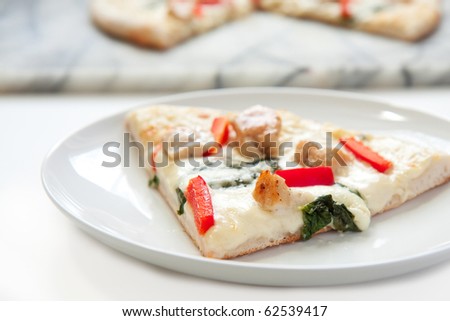 Chicken pizza slice with white sauce, peppers, and basil