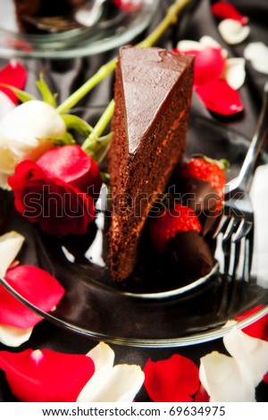 Rich dark chocolate cake with mousse filling accompanied by chocolate covered strawberries and champagne