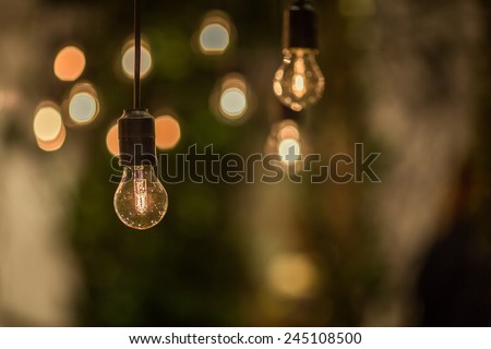 Lighting decor. Retro light bulb filament hanging close up. Illuminated.
