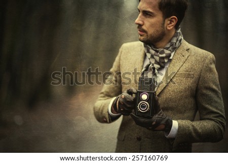 Man with old vintage camera in hands.