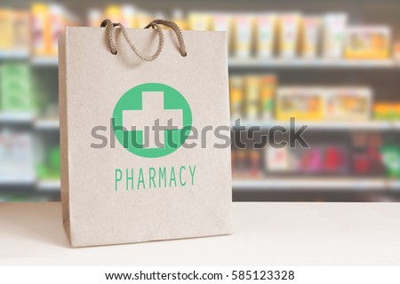 Recycled paper bag with a green Pharmacy logo in a drugstore. Empty copy space for Editor\'s content..