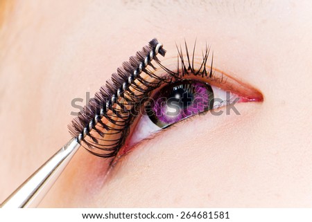 False eyelashes and the purple colored contact lenses which I am operating on
