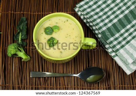 Green Cream broccoli soup.Vegetables around the bowl