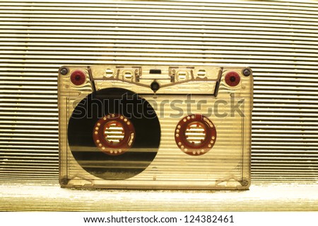 Transparent Cassette tape. Gold color background.