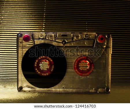Transparent Cassette tape. Gold color background.