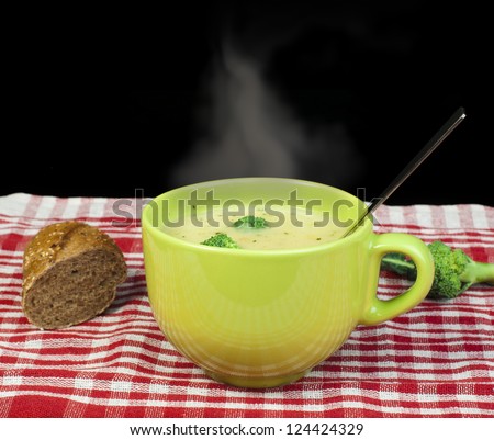 Green Cream broccoli steaming soup.Vegetables around the bowl