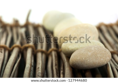 Stacked stones on wooden base. White isolated.