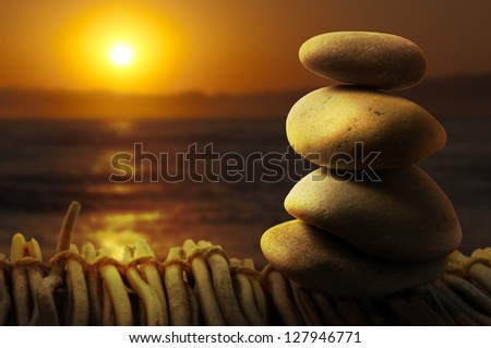 Stacked stones on wooden base for spa. Sunrise background