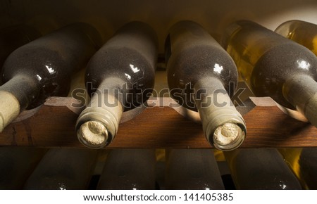 Wine bottles on shelf. Wine cellar. Close up wine bottles.