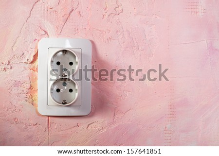 White socket on pink wall. Double socket