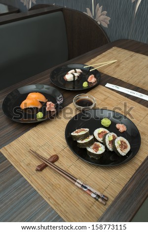 Sushi in sushi bar. Table and ration sushi
