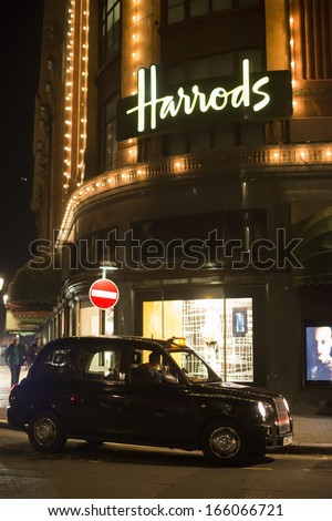 LONDON, UNITED KINGDOM - CIRCA NOVEMBER 2013:Harrods department store. Facade illuminated at night. Taxi parked in front of the building