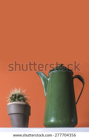 Green vintage kettle on red wall