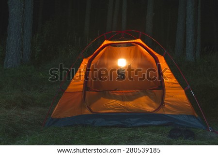 Orange tent in the forest at night