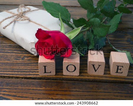 Closeup of the word I LOVE YOU with a red rose and a gift