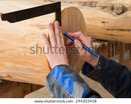 Human male hand with a protractor. Man measures a log