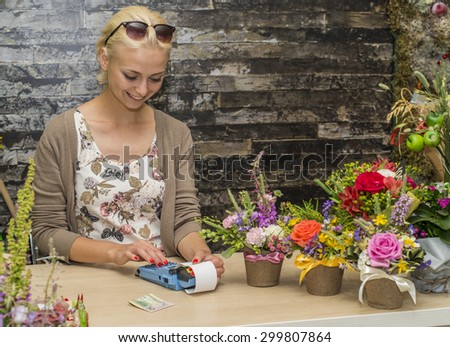 florist girl breaks a check at the store flowers. Focus on the model of the left