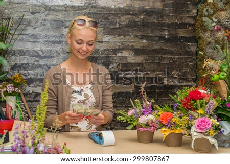 girl counts the money in the store flowers. Focus on the model of the left