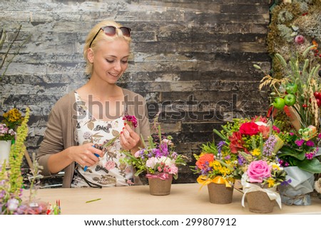 The young beautiful girl-florist does  floral arrangement. Focus on the model of the left