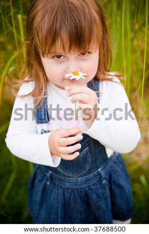 pretty little girl smelling a flower