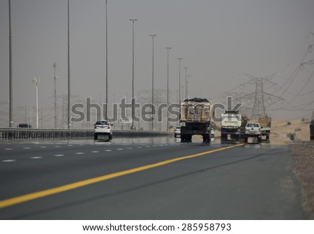 Trucks driving on a desert motorway in the United Arab Emirates with heat haze