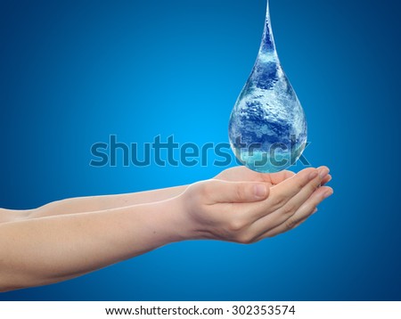 Concept or conceptual blue water or liquid drop falling in two woman hands on blue gradient background