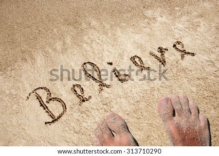 Concept believe handwritten text in sand on a beach in an exotic island with feet for summer, ocean, sea, travel, vacation, tourism, tropical, coast, message, resort, paradise, sunny or water