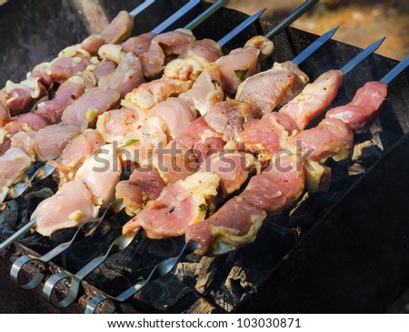 many roast meat pieces get on skewer. shish kebab cooking process