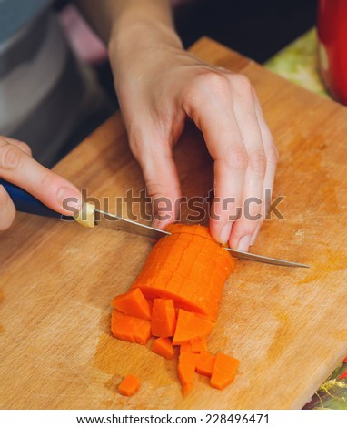 food preparation. cutting red carrot for vegetarian table