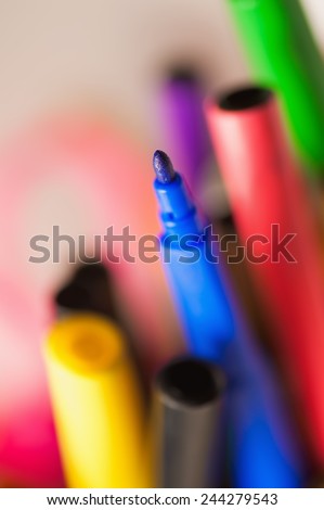 many coloured felt tip standing in a box. Selective focus on a blue tip with motion blur effect backgrounds