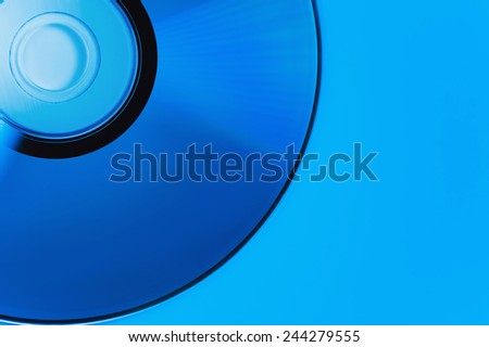 compact disk on blue backgrounds. This colour not computer effect. It is dark blue illumination lamp. Soft focus
