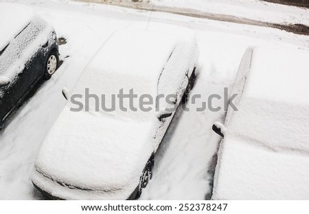 top view of car cover after snowfall. On a snow - no noise. This is a snow surface. Focus on a windshield of center car.