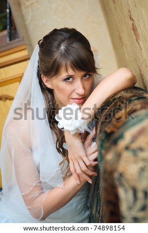 Portrait of the pensive bride in home environment. holding hand in hand. elegant woman