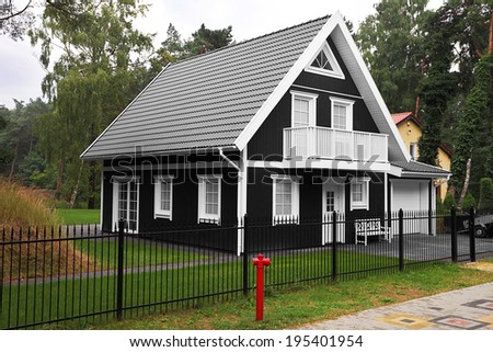 Rustic black and white wooden summer cottage near the forest