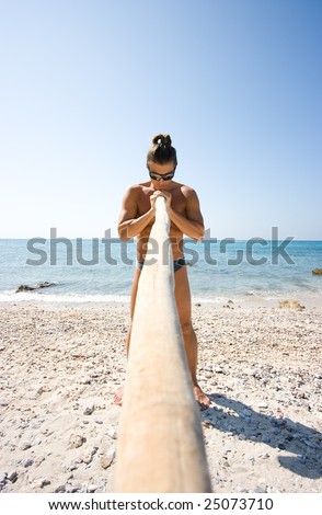 Young man standing with bamboo stick on the beach
