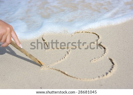 Painting two hearts on the beach sand
