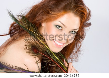 stock photo Red hair beauty with peacock feathers in hands