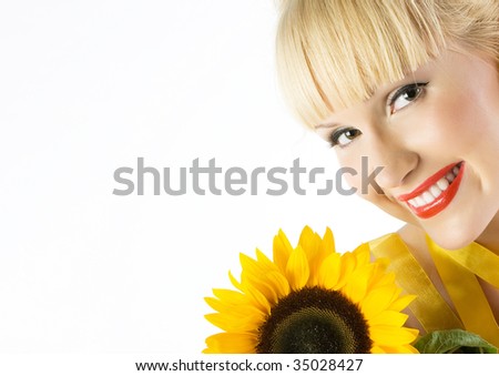 Close-up beautiful funny young fresh blonde smiling with sunflower in studio shot with beautiful make-up