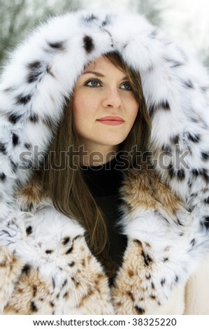 Beautiful brunette lady in fur coat in the winter