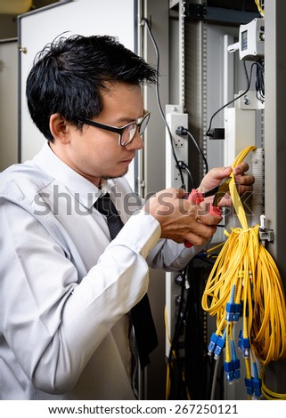 Network engineer cutting fiber optic cable