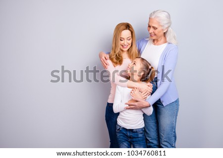 Family concept. Portrait of adorable lovely cute family generation standing hugging together wearing casual clothed isolated on gray background copyspace