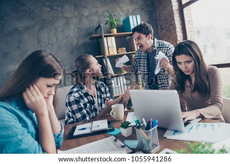 Tired aggressive unsatisfied angry mad crazy colleagues are having scandal at workstation and crumpling papers, they want to fight, women are trying to remain silence
