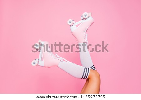 Close up photo of woman\'s body part. Legs wearing cute sweet with shoelaces four wheeled roller blades isolated tanned bright vivid background