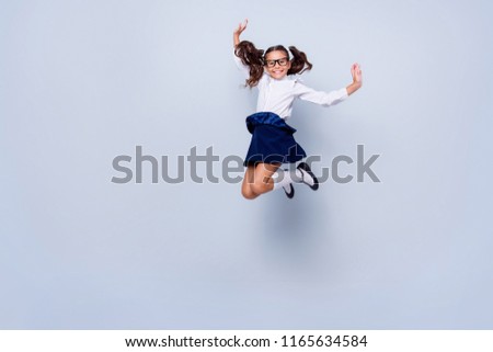 Full length, legs, body, size portrait of beautiful, pretty, charming, carefree, careless small girl in black low shoe jumping isolated on light gray background raised hand up
