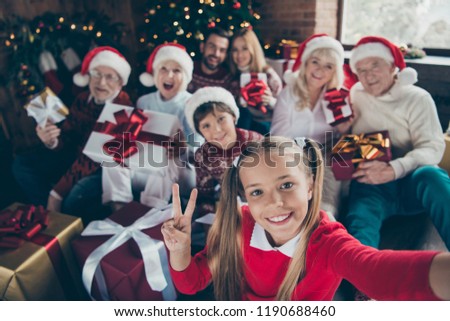 Self-portrait of noel family gathering. Grey-haired grandparents, granddaughter, grandson, grandchildren, brother, sister keeping, getting gifts, showing two fingers, peace symbol, v-sign, fun joy
